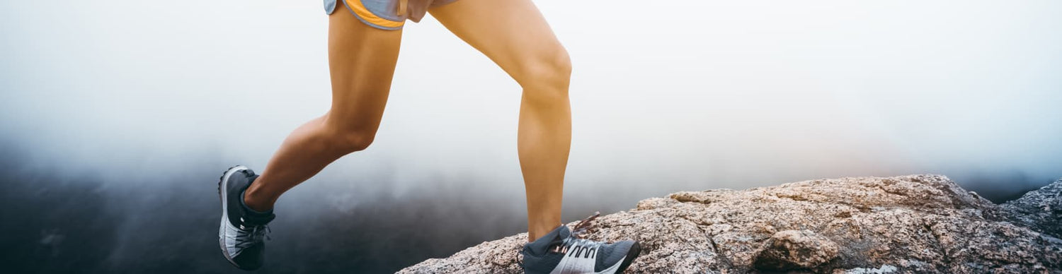 Person hiking on a rocky trail with a mountainous background